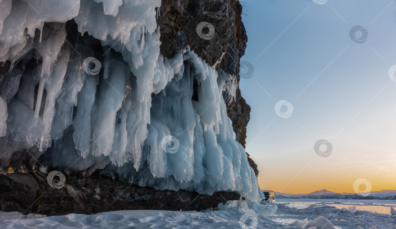 Скачать Причудливые сосульки свисают с подножия гранитной скалы. фотосток Ozero