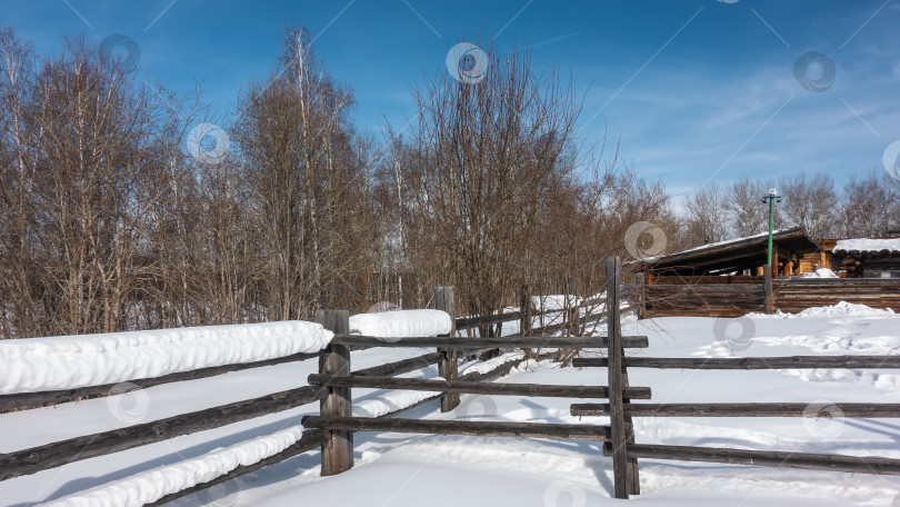 Скачать Толстые слои снега лежат на старом некрашеном деревянном заборе. фотосток Ozero