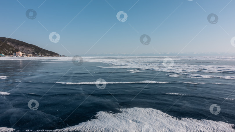 Скачать Пятна снега лежат на гладком голубом льду замерзшего озера. фотосток Ozero