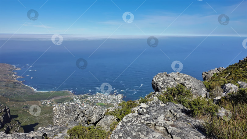 Скачать Голубой Атлантический океан и лазурное небо видны с вершины Столовой горы в Кейптауне. фотосток Ozero