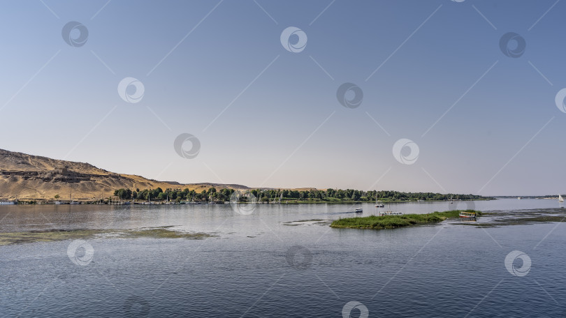 Скачать На спокойной голубой воде Нила виден небольшой зеленый остров. фотосток Ozero
