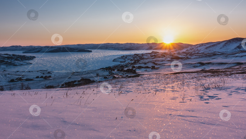 Скачать Лучи восходящего солнца освещают горный хребет и замерзшее озеро. фотосток Ozero