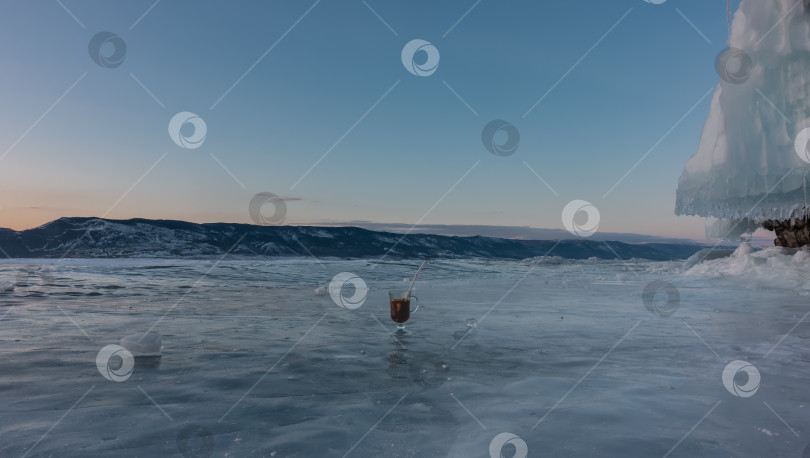 Скачать На замерзшем озере стоит стеклянная кружка с глинтвейном. фотосток Ozero