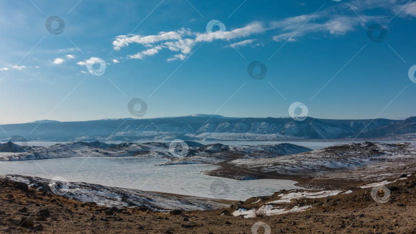 Скачать Замерзшее озеро окружено холмами. фотосток Ozero