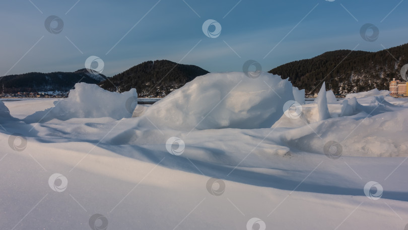 Скачать На замерзшем озере ледяной снег образует причудливые фигуры. фотосток Ozero