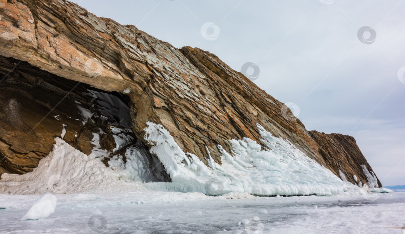 Скачать Причудливый остров-скала возвышается над замерзшим озером. фотосток Ozero