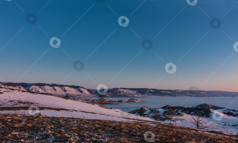 Скачать Раннее зимнее утро в Сибири. Замерзшее озеро окружено горами. фотосток Ozero