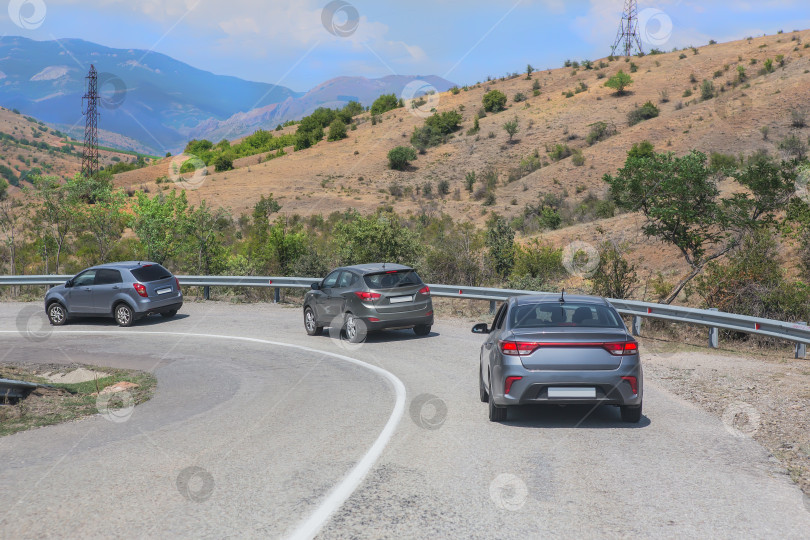 Скачать Автомобили движутся по извилистой дороге в горах фотосток Ozero