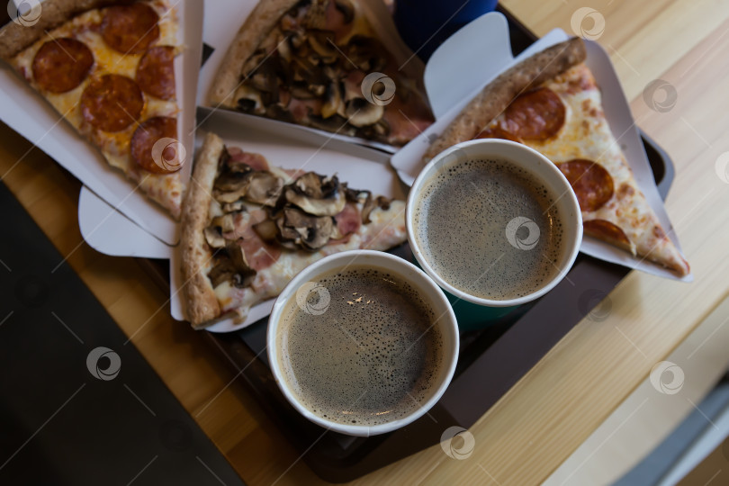 Скачать Кофе и кусочки пиццы на столе фотосток Ozero