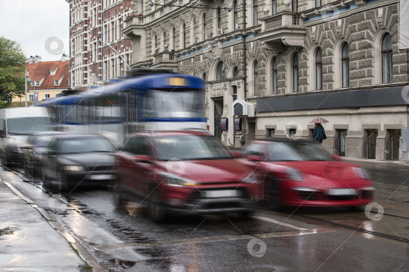 Скачать Автомобильное движение в центре города во время дождя. фотосток Ozero