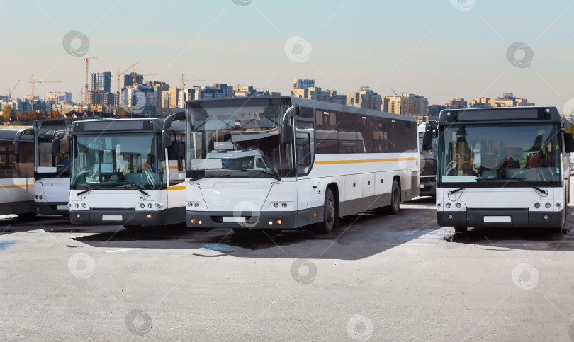 Скачать Автобусы на стоянке посреди городского пейзажа фотосток Ozero