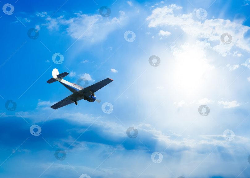 Скачать спортивный самолет летит в голубом облачном небе фотосток Ozero