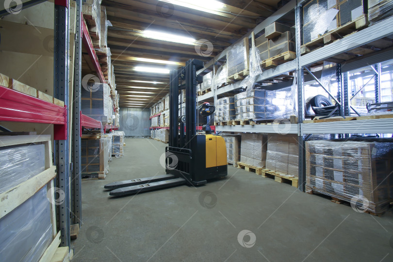 Скачать Интерьер склада со стеллажами, коробками и вилочным погрузчиком фотосток Ozero