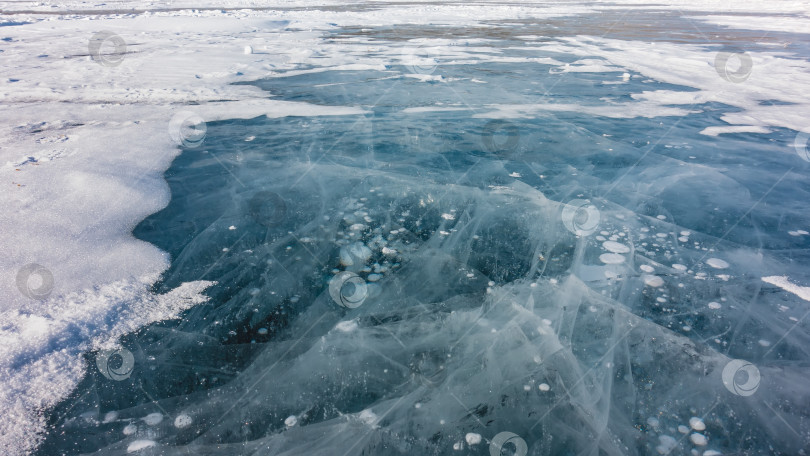 Скачать Прозрачный бирюзовый лед замерзшего озера. Крупный план. фотосток Ozero