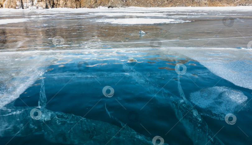 Скачать Голубой прозрачный лед замерзшего озера. Крупный план. фотосток Ozero