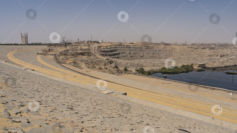 Скачать Асуанская плотина в Египте. Песчано-каменистая почва на берегах Нила, технические сооружения, линии электропередач. фотосток Ozero