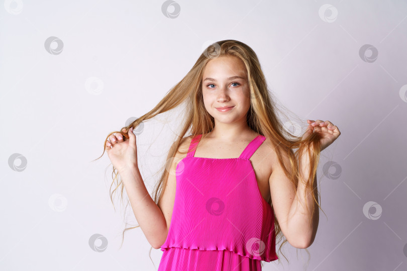 Скачать Симпатичная девушка на белом фоне играет с волосами фотосток Ozero