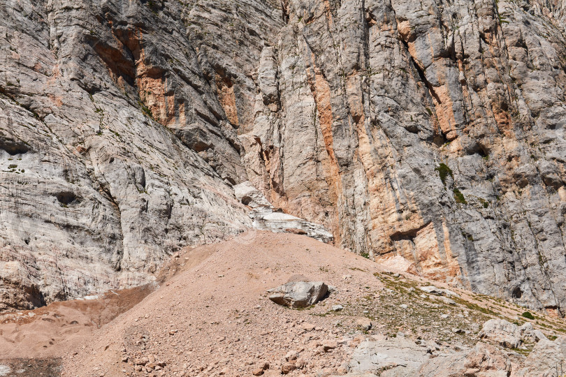 Скачать осыпь у подножия отвесной скалы в горной местности фотосток Ozero