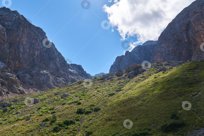 Скачать альпийская ледниковая долина с крутыми склонами, травянистым дном и облаками фотосток Ozero