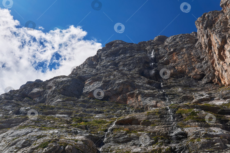 Скачать отвесная скала с водопадом на фоне неба фотосток Ozero