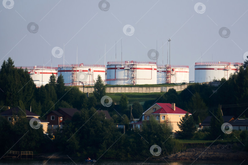 Скачать нефтехранилище на холме над деревней на берегу в Перми, Россия фотосток Ozero