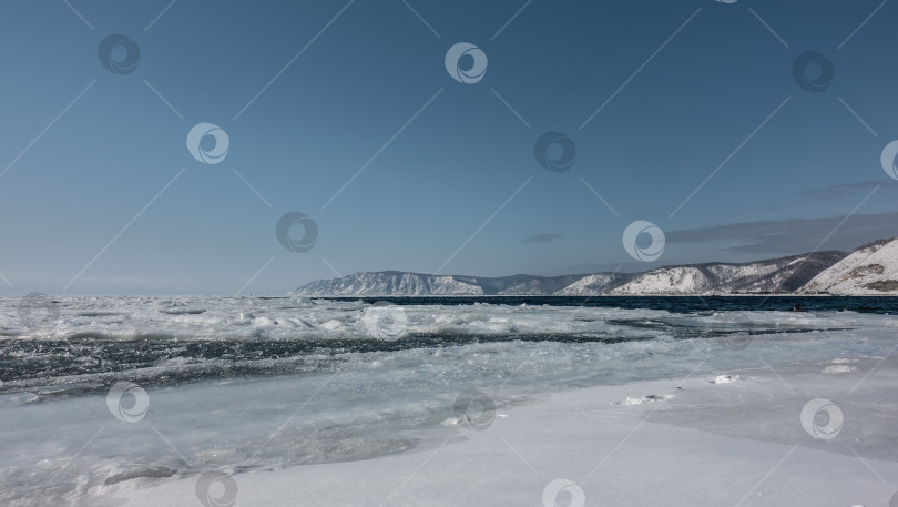 Скачать Лед на реке начинает таять. Следы на снегу у берега. фотосток Ozero