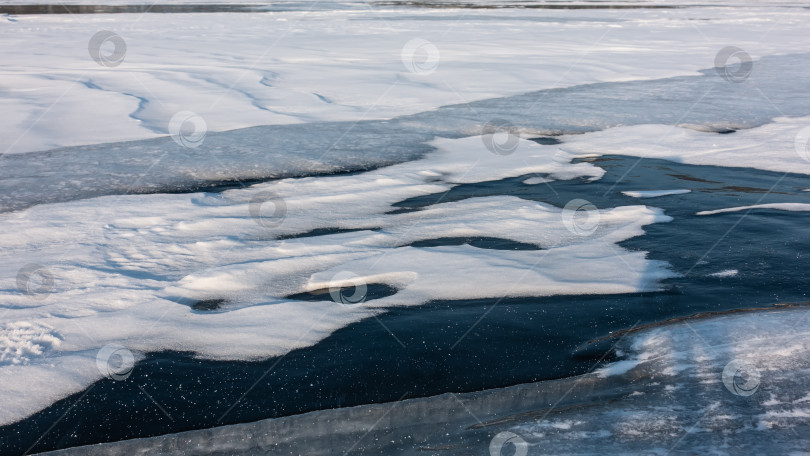 Скачать Замерзшее озеро покрыто толстым голубым льдом. фотосток Ozero