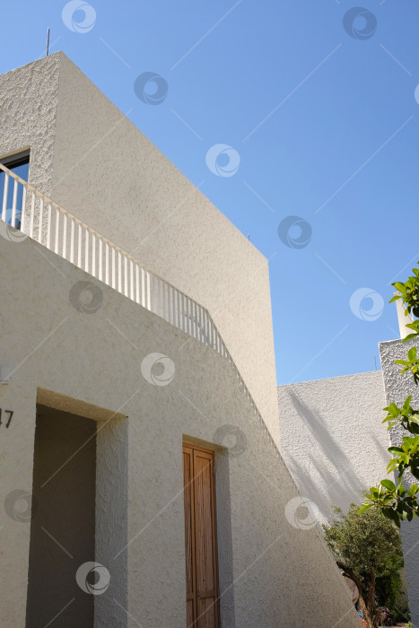 Скачать Отель в Бодруме, минималистичные белые здания с окнами на фоне голубого неба. фотосток Ozero