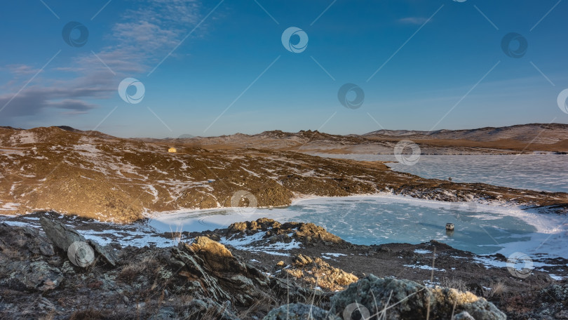 Скачать Замерзшее озеро в форме сердца окружено холмами. фотосток Ozero