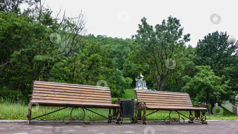 Скачать На мощеном тротуаре в парке есть две деревянные скамейки. фотосток Ozero