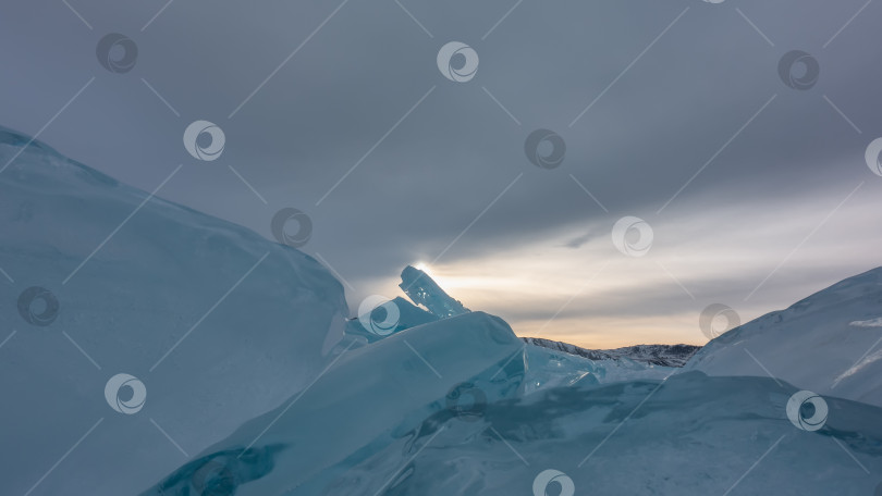Скачать Глыба бирюзового льда возвышается на фоне вечернего облачного неба. = фотосток Ozero