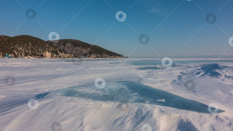 Скачать Лед и снег лежат на поверхности замерзшего озера. фотосток Ozero