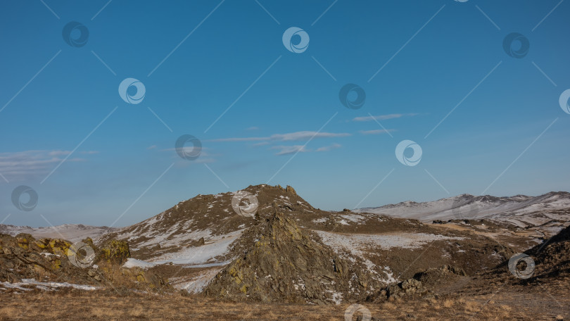 Скачать Склоны холмов, лишенные растительности, покрыты снегом. фотосток Ozero