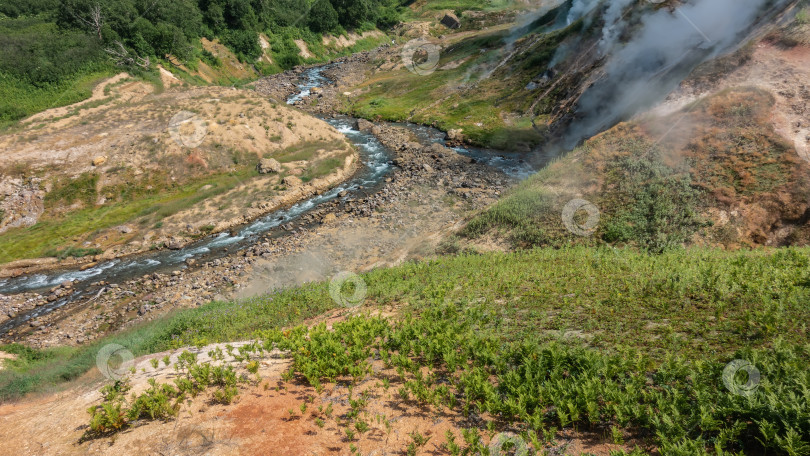 Скачать Река течет по каменистому руслу в долине гейзеров. фотосток Ozero