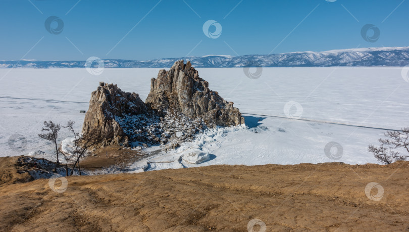 Скачать Живописная гранитная двуглавая скала на фоне замерзшего озера. фотосток Ozero