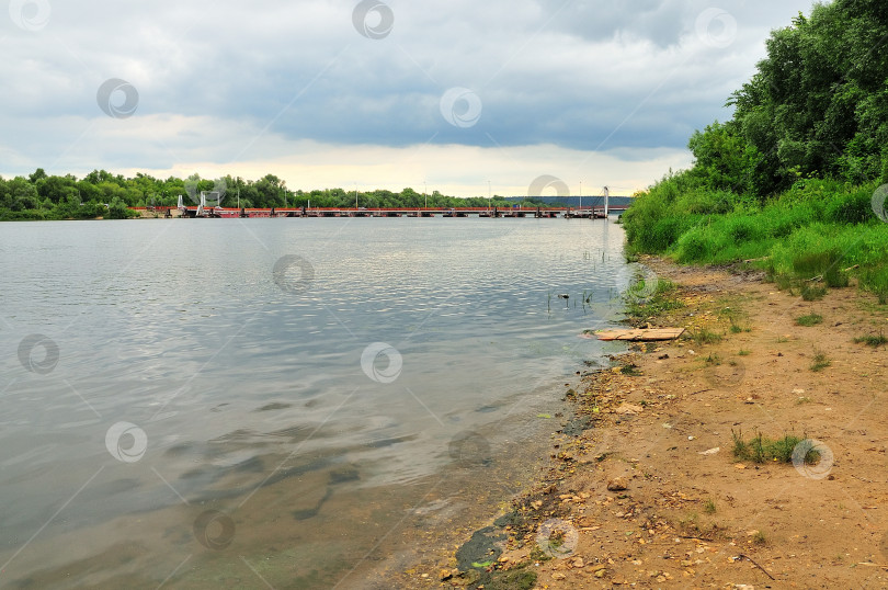 Скачать Вид на разводной мост через Оку в районе города Озеры под пасмурным небом на фоне водной глади реки фотосток Ozero