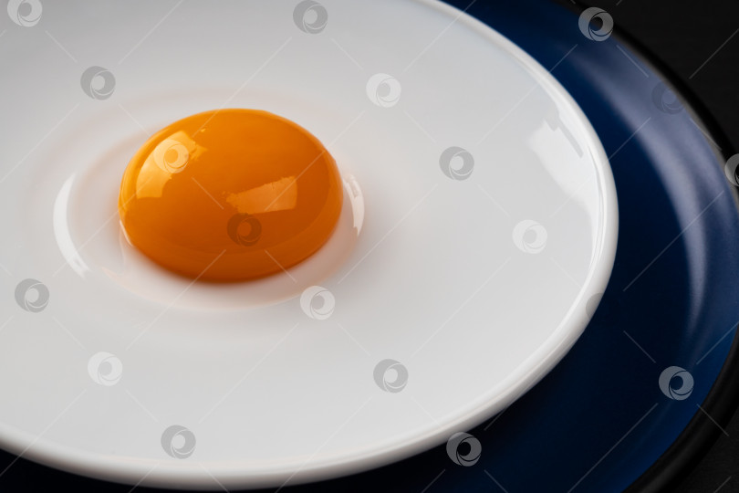 Скачать Яичный желток выложите на тарелку. Абстрактная яичница-глазунья. Закрыть. фотосток Ozero