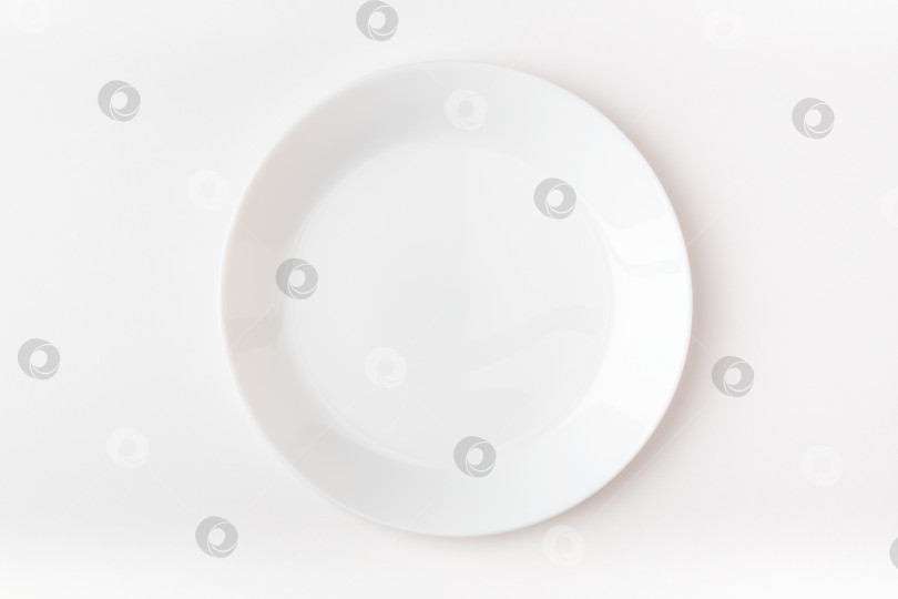 Скачать Пустая белая тарелка на белом фоне. Пустая тарелка. Вид сверху. фотосток Ozero