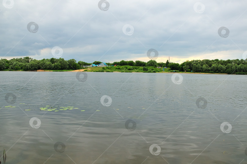 Скачать Вид на пляж на другом берегу реки Ока под пасмурным небом фотосток Ozero