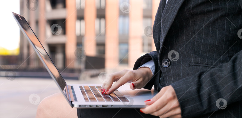 Скачать Молодая серьезная деловая женщина с ноутбуком учится онлайн, сидя на скамейке фотосток Ozero