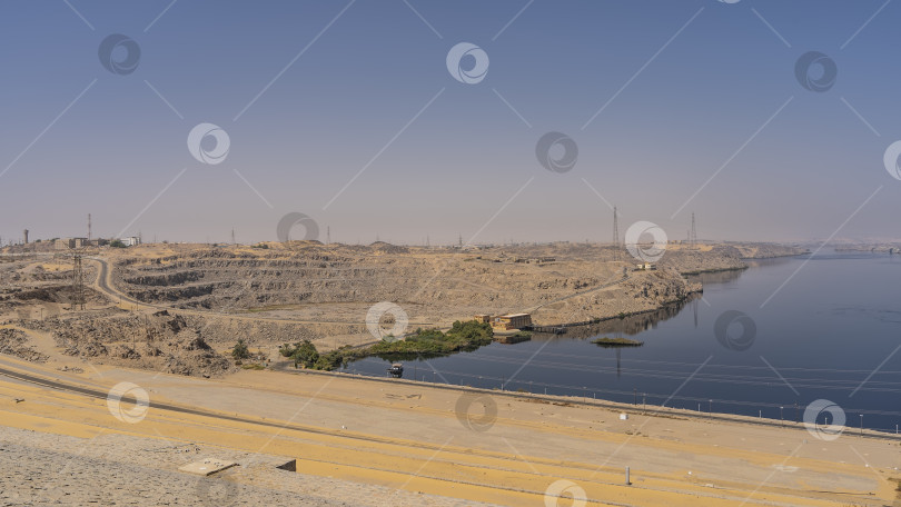 Скачать Асуанская плотина. Вы можете видеть шоссе, технологические сооружения на берегу, линии электропередач. фотосток Ozero