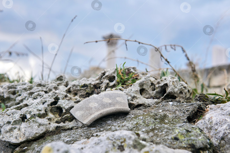 Скачать осколок древней керамики на камне на фоне голубого фотосток Ozero