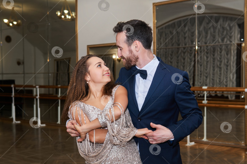 Скачать мужчина и женщина танцуют, глядя друг на друга, в пустом бальном зале фотосток Ozero