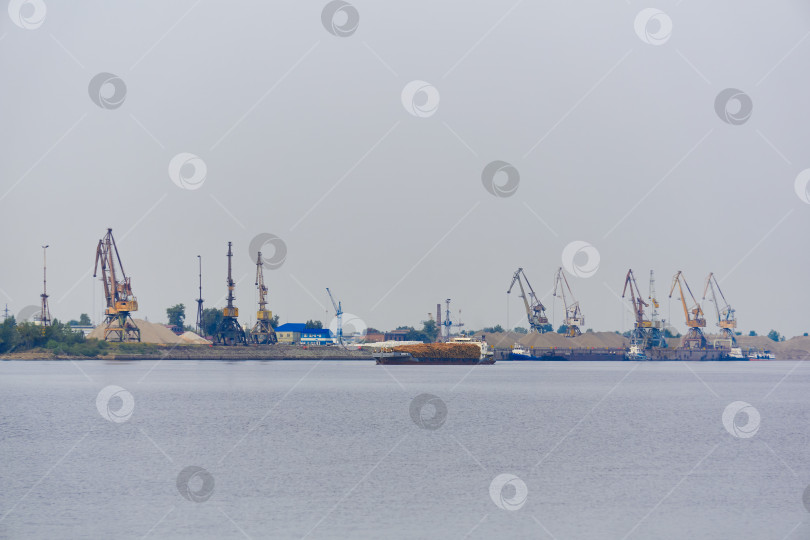 Скачать промышленный речной пейзаж с грузовым судном для перевозки древесины и грузовым терминалом фотосток Ozero