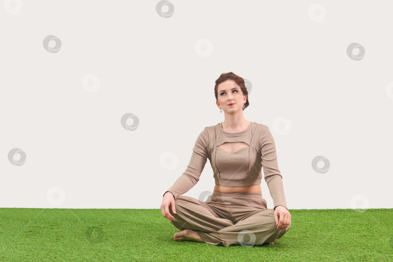 Скачать молодая женщина сидит в позе медитации и мечтательно смотрит вверх на фотосток Ozero