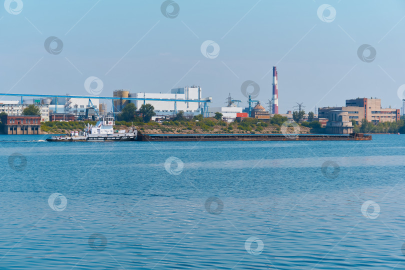 Скачать буксир толкает баржу с сухогрузом по реке мимо промышленного фотосток Ozero