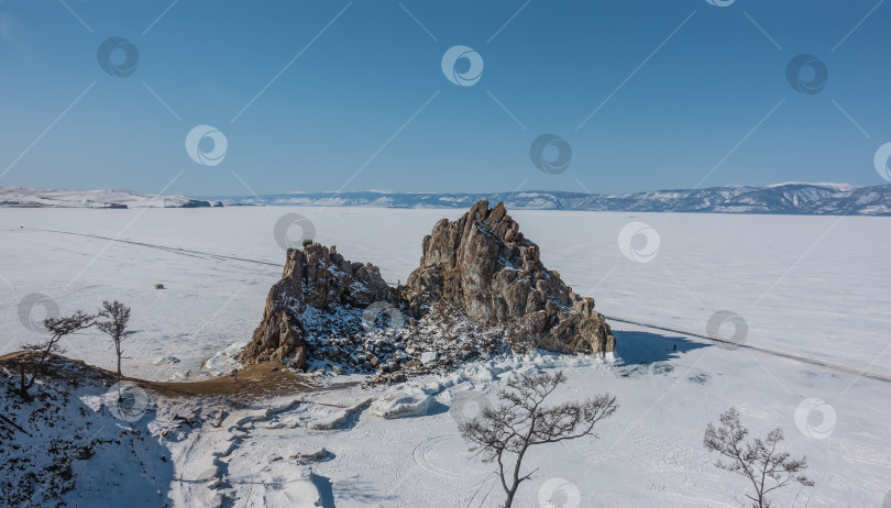Скачать Живописная двуглавая гранитная скала на фоне замерзшего озера. фотосток Ozero