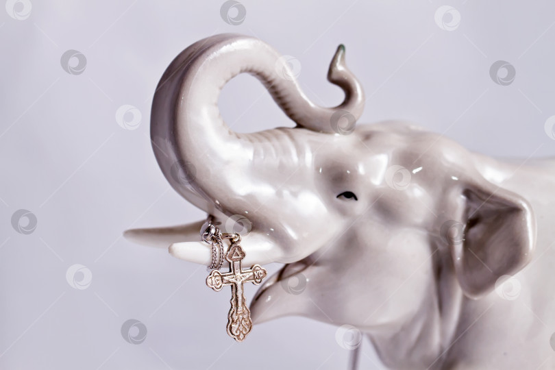 Скачать Фарфоровый слоник с серебряным крестом в руках фотосток Ozero