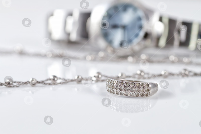 Скачать Серебряное кольцо и цепочка на фоне часов фотосток Ozero