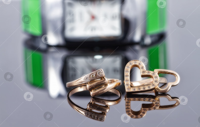 Скачать Золотые кольца разной формы и металлические женские часы фотосток Ozero